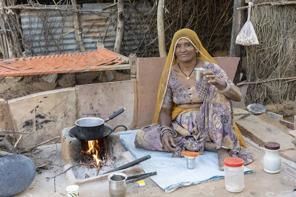 プシュカル、ラジャスタン、インドの近くで彼女の家族のためにお茶を作るインドの女性 — ストック写真