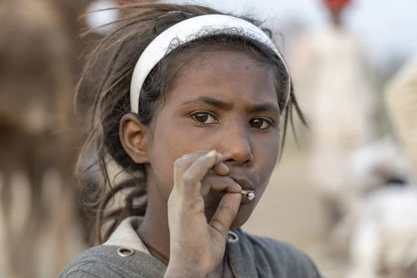 Indiano povera ragazza fumare sigaretta in tempo Pushkar Camel Mela, Rajasthan, India, primo piano ritratto — Foto Stock