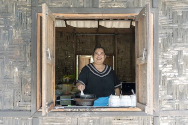 Tay kadın aşçı ada Koh Phangan, Tayland bir plaj kafede yemekleri hazırlamak. Sokak tay gıda, yakın