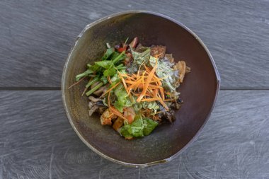 Yeşil köri pirinç, patlıcan, kimchi, kızarmış yeşillik, mantar, tempeh pastırma, tofu organik salata bir kil kase servis edilir. Yakın çekim