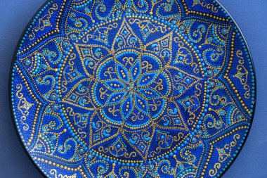 Mavi ve altın rengi nde dekoratif seramik tabak, boyalı tabaklar, closeup. Akrilik boyalar ile boyanmış dekoratif porselen plaka, el işi