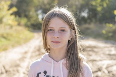 Güzel sarışın genç kız açık havada doğa sonbahar, arka planda üzerinde çilli kapatmak dikey