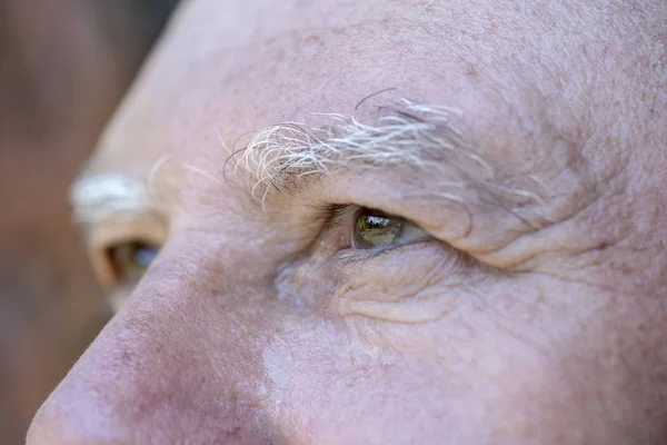 Zbliżenie oko kaukaski starzec. Portret staruszka na zewnątrz. Kaukaski mężczyzna twarz tło, zbliżenie oczy, makro — Zdjęcie stockowe