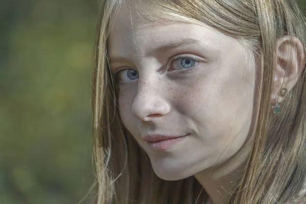 Bella bionda giovane ragazza con lentiggini all'aperto sullo sfondo della natura in autunno, ritratto da vicino — Foto Stock