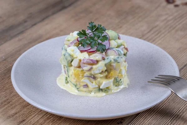 Ahşap arka plan üzerinde bir tabakta salatalık, turp ve krema soslu yumurta ile lezzetli salata. Sağlıklı gıda, yakın — Stok fotoğraf