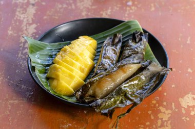 Tay tarzı tatlı, palmiye yapraklarımuz yapışkan pirinç ile sarı mango. Sarı mango ve yapışkan pirinç Tayland popüler geleneksel tatlı.