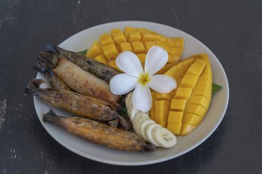 Tay tarzı tatlı, palmiye yapraklarımuz yapışkan pirinç ile sarı mango. Sarı mango ve yapışkan pirinç Tayland popüler geleneksel tatlı.