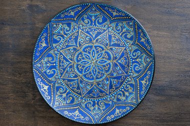 Mavi ve altın rengi nde dekoratif seramik tabak, boyalı tabaklar, closeup. Akrilik boyalar ile boyanmış dekoratif porselen plaka, el işi