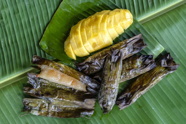 Tay tarzı tatlı, palmiye yapraklarımuz yapışkan pirinç ile sarı mango. Sarı mango ve yapışkan pirinç Tayland popüler geleneksel tatlı.