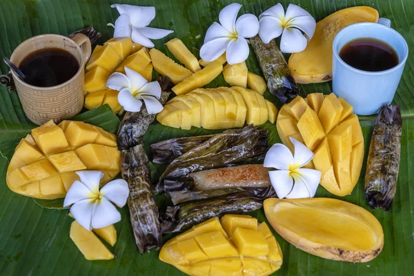 Tay tarzı tatlı, palmiye yapraklarımuz yapışkan pirinç ile sarı mango. Sarı mango ve yapışkan pirinç Tayland popüler geleneksel tatlı.