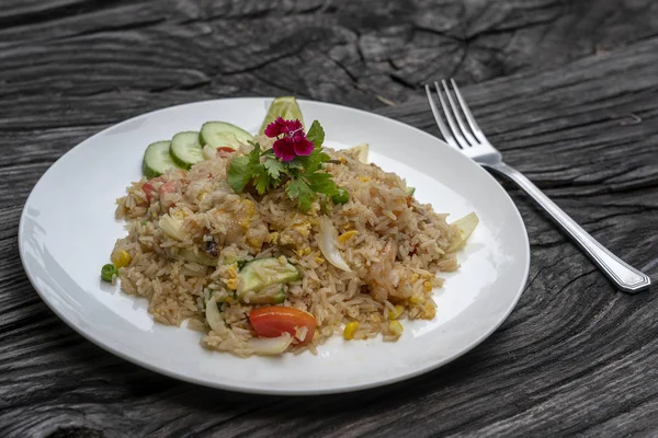 Stekt ris med räkor och grönsaker i en vit skål på ett gammalt träbord, närbild. Thailändsk mat, thailändskt kök — Stockfoto