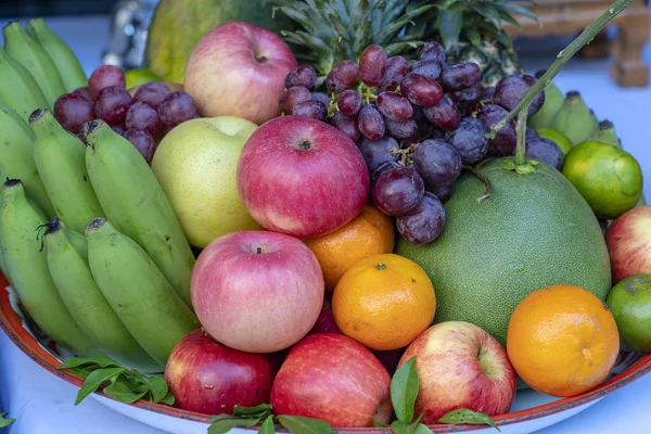 Sortiment av färsk frukt banan, vindruvor, apelsin, äpple, ananas, tangerin och grapefrukt på en bricka. Närbild — Stockfoto