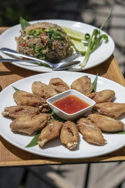 Fried chicken wings with sauce and rice with vegetables on a tray. Thailand. — Stock Photo, Image