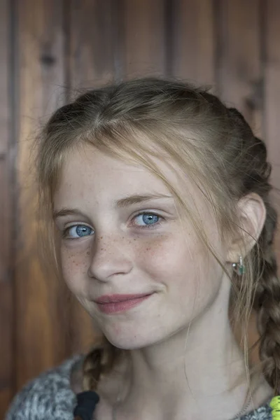 Menina loira bonita com sardas dentro de casa no fundo de madeira, close-up retrato — Fotografia de Stock