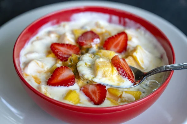 Manga, maracujá, morango e iogurte brulee. Sobremesa de fruto em café da manhã com cunhas de mangas de estação perfeitamente maduras e morango, polpa de maracujá fresca coberta — Fotografia de Stock