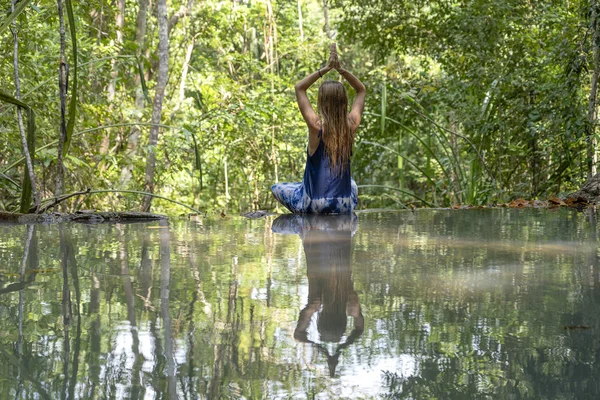 Bella donna che pratica yoga vicino all'acqua turchese della cascata a cascata nella foresta pluviale tropicale profonda, isola di Koh Phangan, Thailandia — Foto Stock