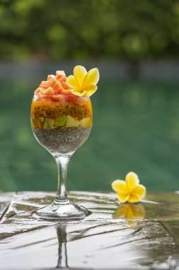 Papaya ile Chia tohumları puding , tutku meyve, mango ve avokado yüzme havuzu su arka planda kahvaltı için bir bardak, closeup. Sağlıklı beslenme kavramı, superfood
