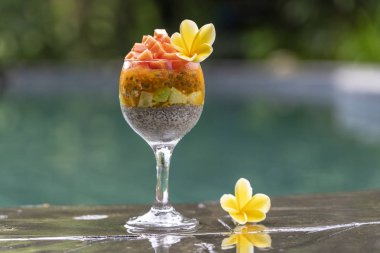 Papaya ile Chia tohumları puding , tutku meyve, mango ve avokado yüzme havuzu su arka planda kahvaltı için bir bardak, closeup. Sağlıklı beslenme kavramı, superfood