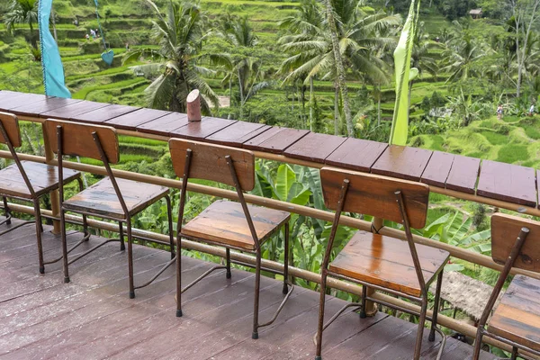 Wooden table and chairs in empty tropical cafe next to rice terraces in island Bali, Indonesia — Stock Photo, Image