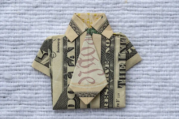 Origami shirt made of dollar banknote on white fabric background. Closeup. Dollar bill T-shirt — Stock Photo, Image