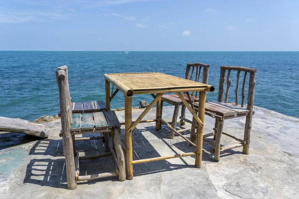 Bambustisch und Holzstühle in einem leeren Café neben dem Meerwasser am tropischen Strand. island koh phangan, thailand — Stockfoto