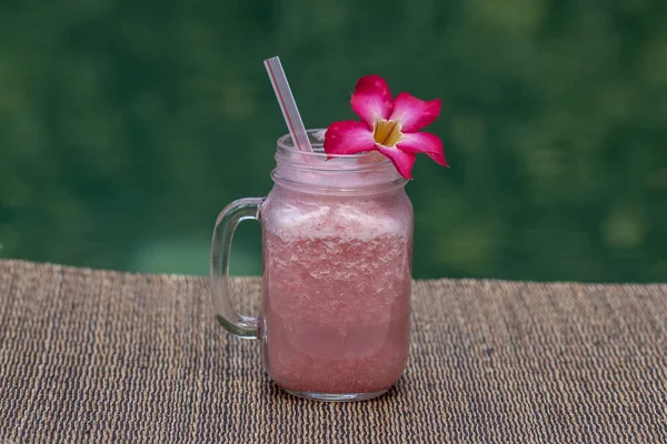Rosa grapefrukt shake eller smoothie på bordet, på nära håll. Frukost på ön Bali i Indonesien — Stockfoto