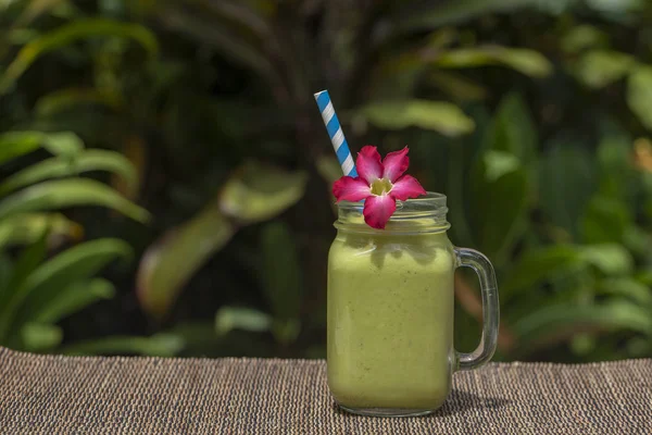 Avokáda zelené třást nebo smoothie na stole, zblízka. Snídaně v ostrově Bali, Indonésie — Stock fotografie