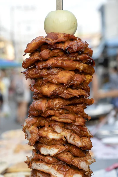 Grandes pedaços de carne em um cuspo no mercado de comida de rua na Tailândia. Carne de chiken espetada no espeto. Fast food . — Fotografia de Stock