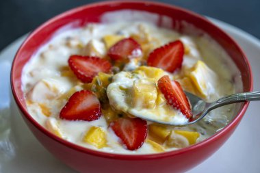 Mango, tutku meyve, çilek ve yoğurt brulee. Mevsimlik mango ve çilek mükemmel olgunlaşmış takozlar ile kahvaltıda meyve tatlı, taze tutku meyve hamuru kaplı