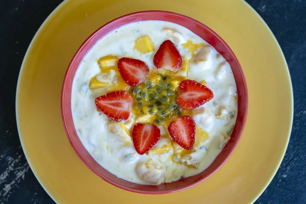 Manga, maracujá, morango e iogurte brulee. Sobremesa de fruto em café da manhã com cunhas de mangas de estação perfeitamente maduras e morango, polpa de maracujá fresca coberta — Fotografia de Stock