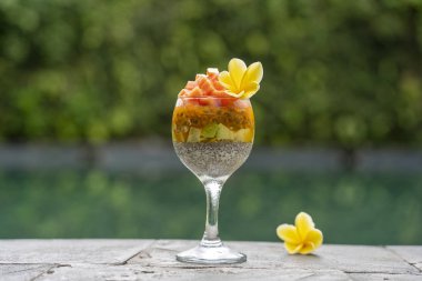 Papaya ile Chia tohumları puding , tutku meyve, mango ve avokado yüzme havuzu su arka planda kahvaltı için bir bardak, closeup. Sağlıklı beslenme kavramı, superfood