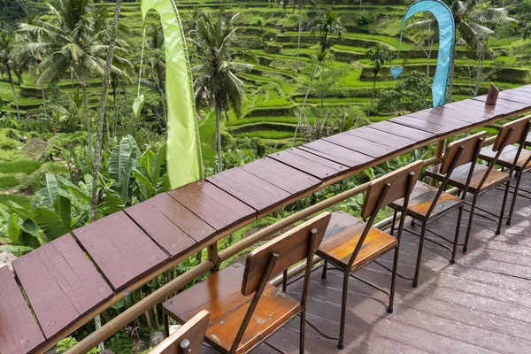 Mesa y sillas de madera en un café tropical vacío junto a terrazas de arroz en la isla de Bali, Indonesia —  Fotos de Stock