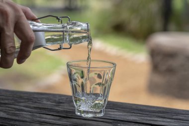 Bir restoranda bir garson bir bardak içine bir şişe den tatlı su döker, yakın