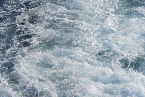 Salpicaduras de agua de mar azul durante el movimiento del barco . — Foto de Stock