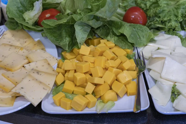 Assortiment kaas, close-up. De achtergrond van vele stukjes verse kaas wordt tijdens het buffet in blokjes gesneden — Stockfoto