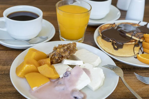 Breakfast of many dishes and drinks on a wooden table, closeup. Food concept — Stock Photo, Image