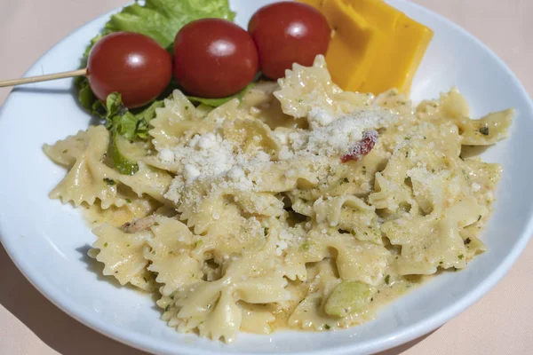 Pasta farfalle with cherry tomato and cheese in white plate, closeup — Stok Foto