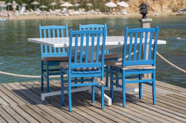 Deniz suyuna yakın plaj kafede masa ve sandalyeler, Bodrum, Türkiye. Denize yakın plaj kafe, açık hava