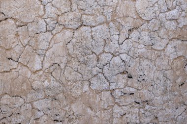 Arka plan olarak bej çimento yüzeyi ile kaplı kırık beton eski duvar. Dokulu arka plan eski kırık duvar