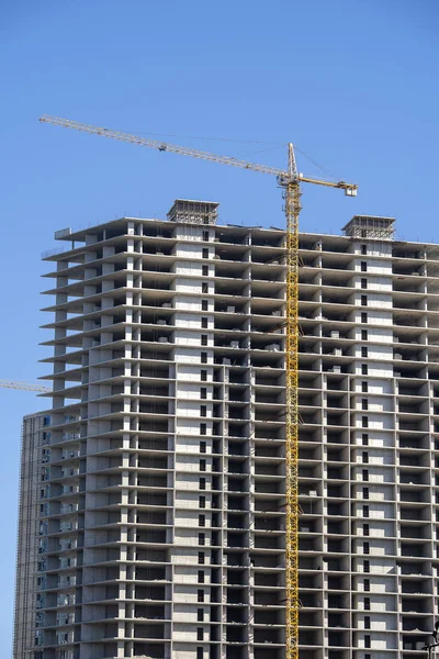 クレーンを備えた高層ビルの建設。建設用クレーンと青空に対する建物. — ストック写真