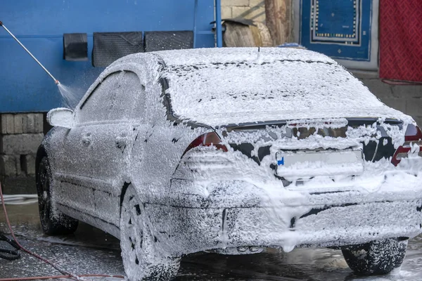 Lavage voiture noire avec mousse active. L'homme lave la machine à mousse. Lavage de voiture . — Photo