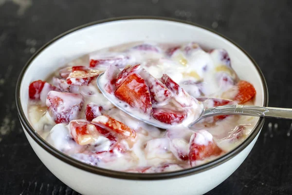 Rote Erdbeere und weißer Joghurt brulee. Fruchtdesserts zum Frühstück mit Keilen perfekt reifer Erdbeeren der Saison, Nahaufnahme — Stockfoto