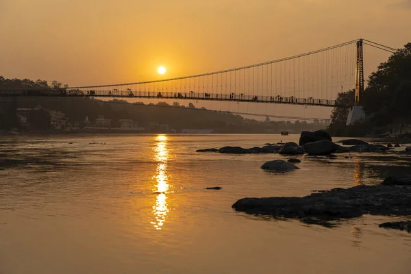 Piękny widok na nabrzeża rzeki Ganges i most o zachodzie słońca. Rishikesh, Indie — Zdjęcie stockowe