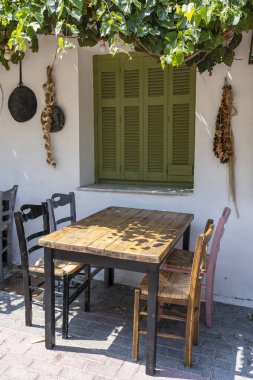 Küçük kafe dış ön görünümü. Masa ve boş sandalyeler beyaz duvarın yanında açık havada. Turistik yerler. Tipik Akdeniz restoranı, yaz aylarında bir yer tatil