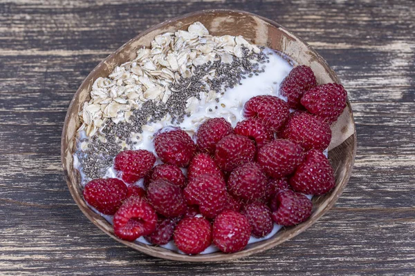 Smoothie em tigela de coco com framboesas, aveia e sementes de chia para o café da manhã, close up. O conceito de alimentação saudável, superalimento — Fotografia de Stock