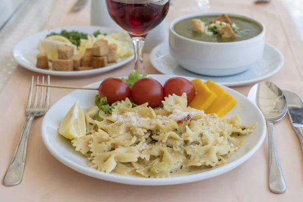 Pasta Farfalle mit Kirschtomaten und Käse auf weißem Teller, Nahaufnahme — Stockfoto