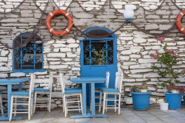 Plaj kafe dış ön görünümü. Masa ve boş sandalyeler taş duvarın yanında açık havada. Turistik yerler. Tipik Akdeniz restoranı, yaz aylarında tatil bir yer. Bodrum, Türkiye