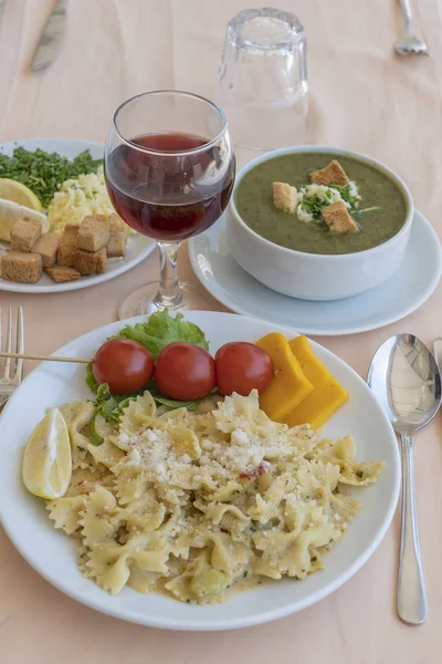 Pasta farfalle con pomodoro ciliegia e formaggio in piatto bianco, primo piano — Foto Stock