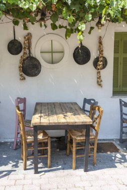 Küçük kafe dış ön görünümü. Masa ve boş sandalyeler beyaz duvarın yanında açık havada. Turistik yerler. Tipik Akdeniz restoranı, yaz aylarında bir yer tatil