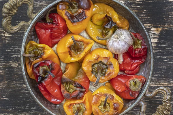 Pimentos vermelhos e amarelos assados. Pimentas em uma assadeira em uma mesa de madeira. Um prato vegetariano saudável e delicioso. Fechar, vista superior — Fotografia de Stock